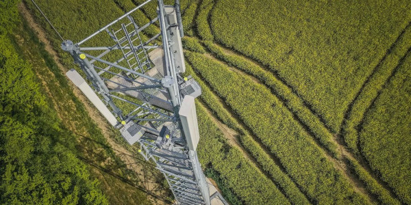 Pylone pour antenne relais GSM 5G FH (faisceau Hertzien), Free Mobile, reseau telephonique mobile haut debit, Telco, Agriculture, champs de Colza, traces de roues de tracteur dans un champ,